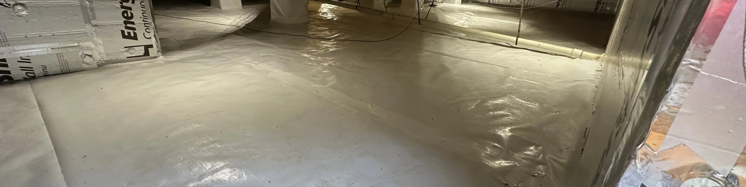 Cary crawl space after encapsulation with a smooth sealed vapor barrier